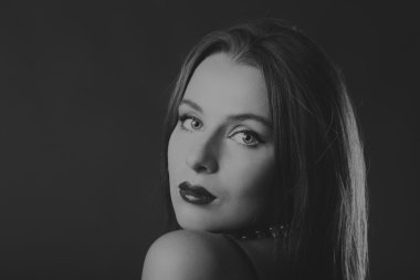 Karanlık bir arka plan üzerinde bir şık elbiseli seksi esmer