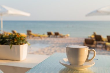 Sahilde bir kafede lezzetli kahve bir fincan. Lezzetli bir içecek. Deniz Manzaralı sakin ol. Fotoğraf dergi, arka planlar, posterler ve Web siteleri için.