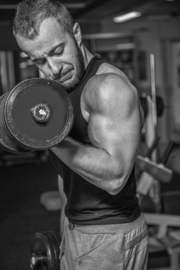 Adam jimnastik salonu. Egzersiz halter kılıyor. Spor, güç, halter, gerginlik, egzersiz - sağlıklı bir yaşam tarzı kavramı. Fitness ve spor hakkında makale.