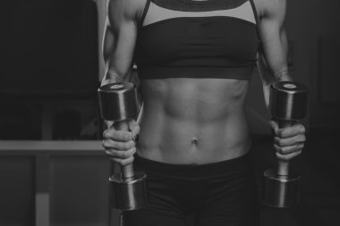 Jimnastik salonu kadın push-up gücü pushup halterle bir fitness egzersiz egzersiz. Egzersizleri yapıyor atletik genç kadın.