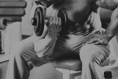 Adam jimnastik salonu. Halter alıştırmalar kılıyor.