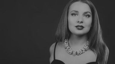 Karanlık bir arka plan üzerinde bir şık elbiseli seksi esmer.