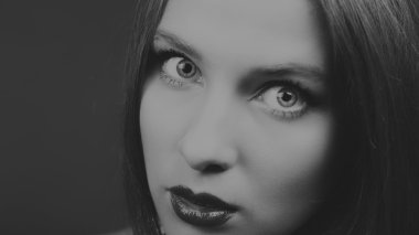 Karanlık bir arka plan üzerinde bir şık elbiseli seksi esmer.