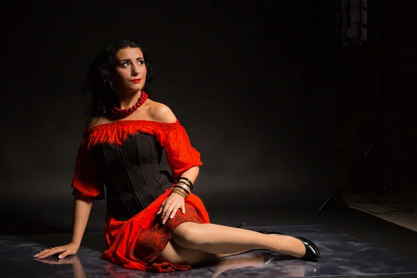 Портрет красивої молодої жінки в червоно-чорній сукні на темному тлі . — стокове фото