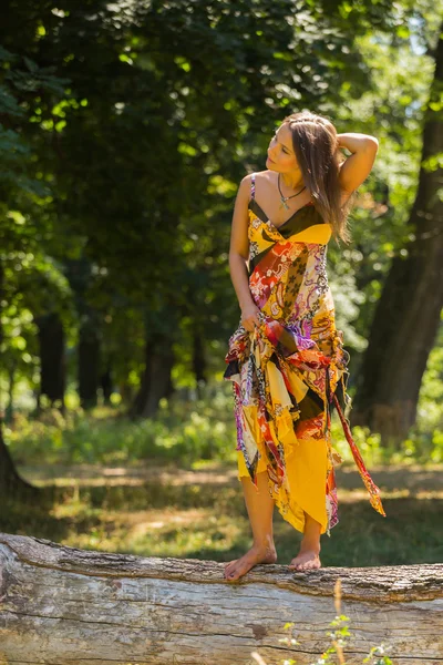 Uma menina jovem e atraente em belo vestido de verão no meio de prados ensolarados. Menina alegre se aquecendo nos raios quentes do sol de verão. Imagem bonita de uma menina despreocupada. Fotos para revistas , — Fotografia de Stock