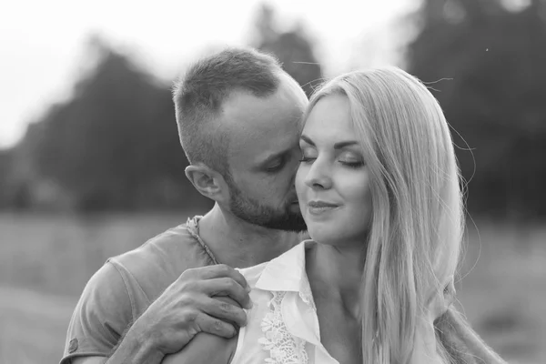 Black and white photo biker couple on a motorcycle in the field. — Stock Photo, Image