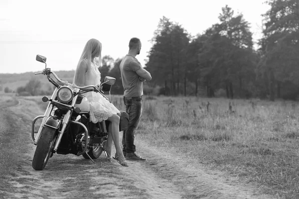 Svartvitt foto biker par på en motorcykel i fältet. — Stockfoto