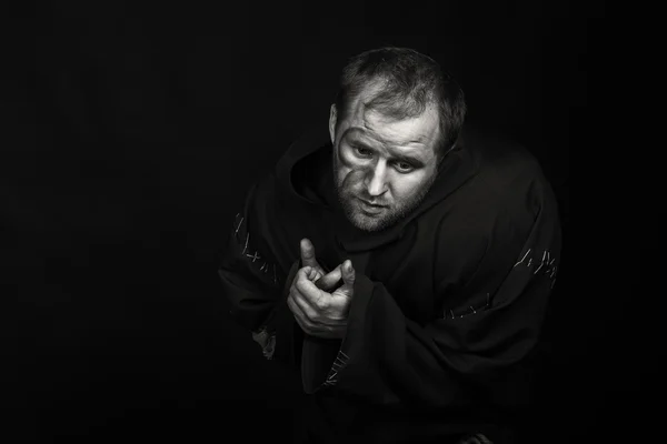 Bellissimo e affascinante attore di teatro gioco sulla macchina fotografica. Foto in bianco e nero dell'attore travestito da mendicante su sfondo scuro. Immagine scenica splendidamente decorata e trucco professionale . — Foto Stock