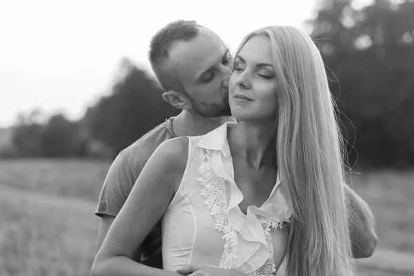 Blanco y negro foto motorista pareja en una motocicleta en el campo . — Foto de Stock