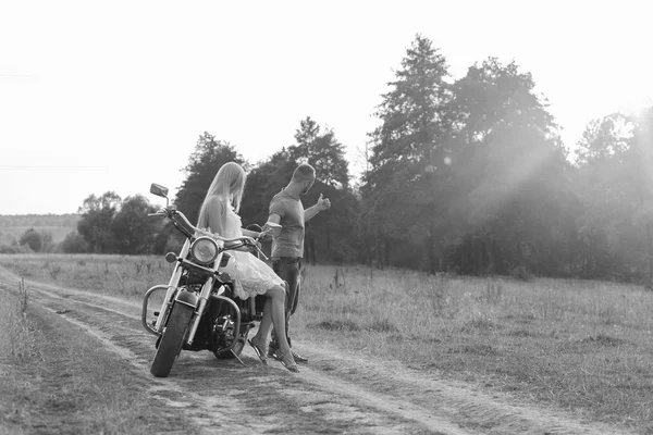 Blanco y negro foto motorista pareja en una motocicleta en el campo . —  Fotos de Stock