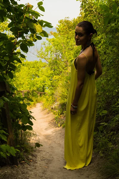 Ritratto della ragazza sullo sfondo di un bellissimo paesaggio naturale. Ragazza in natura in un bellissimo vestito giallo . — Foto Stock