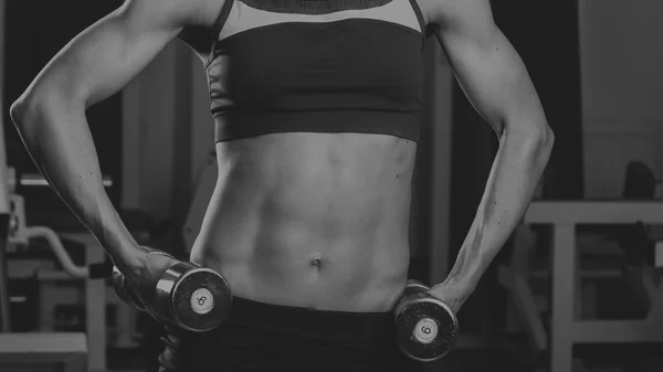 Gym woman push-up strength pushup exercise with dumbbell in a fitness workout. Athletic young woman doing exercises. — Stock Photo, Image