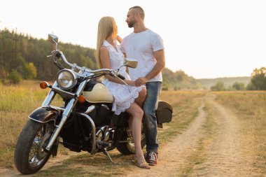 Motorcu ve bir motosiklet üzerinde bir alanda güzel kız.
