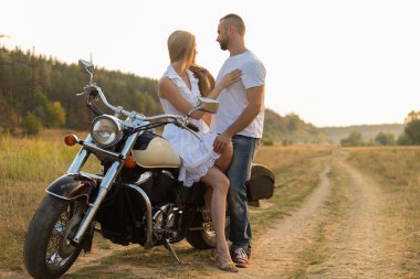 Motorcu ve bir motosiklet üzerinde bir alanda güzel kız.