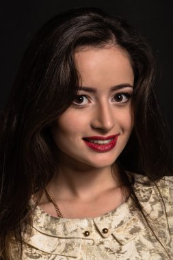 Karanlık bir arka plan üzerinde güzel genç esmer. Seksi seksi esmer. Lüks kadın şık makyaj ile.