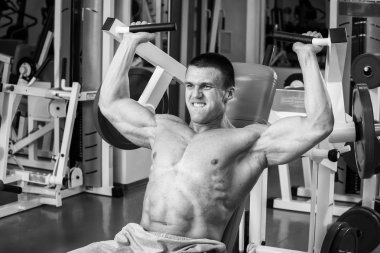 Kaslı adam spor salonunda ağırlık ile çalışma dışarı. Adam egzersizleri yapar.