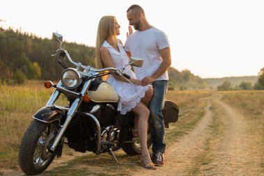 Motorcu ve bir motosiklet üzerinde bir alanda güzel kız.
