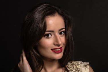 Karanlık bir arka plan üzerinde güzel genç esmer. Seksi seksi esmer. Lüks kadın şık makyaj ile.