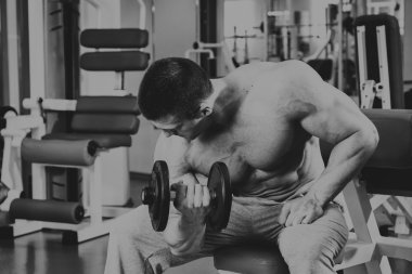 Vücut geliştirmeci yapar egzersiz jimnastik salonu dumbbells ile.