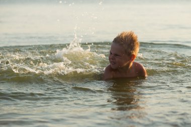 5 yıl denizde oynayan bir çocuk. Bir çocuk denizde yüzüyor.