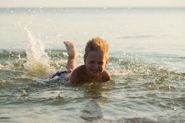 5 yıl denizde oynayan bir çocuk. Bir çocuk denizde yüzüyor.