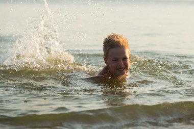 5 yıl denizde oynayan bir çocuk. Bir çocuk denizde yüzüyor.