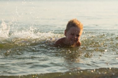 5 yıl denizde oynayan bir çocuk. Bir çocuk denizde yüzüyor.