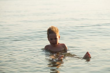 5 yıl denizde oynayan bir çocuk. Bir çocuk denizde yüzüyor.