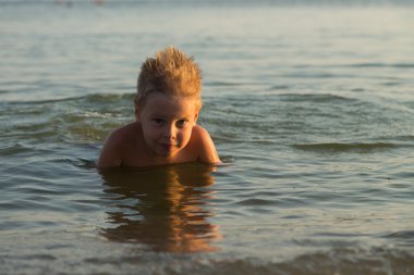 5 yıl denizde oynayan bir çocuk. Bir çocuk denizde yüzüyor.
