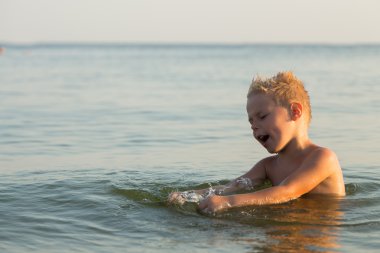 5 yıl denizde oynayan bir çocuk. Bir çocuk denizde yüzüyor.