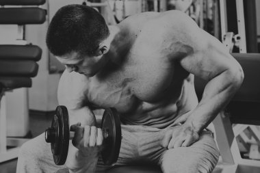 Vücut geliştirmeci yapar egzersiz jimnastik salonu dumbbells ile.