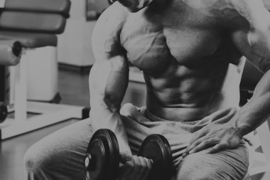 Vücut geliştirmeci yapar egzersiz jimnastik salonu dumbbells ile.