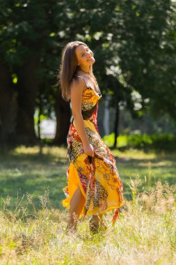 Güneşli Çayırlar orta elbise güzel yaz aylarında genç ve çekici bir kız. Neşeli kız yaz güneş sıcak ışınlarının tadını çıkarma. Kaygısız bir kız güzel görüntüsü. Dergi için fotoğraf,