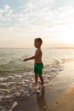 Sahilde erkek şort. Deniz kum ile oynayan çocuk. Sevinç ve eğlenceli çocuklar için. Güzel sıcak bir gün. Çocuk dergi ve Web siteleri için fotoğraf.