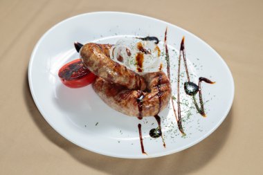 Izgarada pişirme. Izgara sosis kızartma. Izgara menü. Domuz sosisi bir plaka üzerinde.