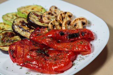 Beyaz tabakta lezzetli çeşitli ızgara sebze.