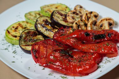 Beyaz tabakta lezzetli çeşitli ızgara sebze.