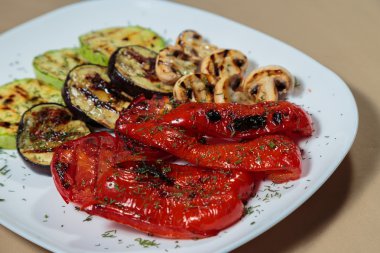 Beyaz tabakta lezzetli çeşitli ızgara sebze.