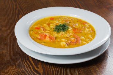 Çorba, sebze ve otlar beyaz plaka.