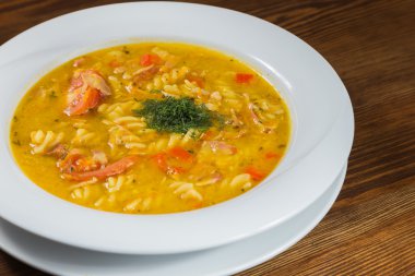 Çorba, sebze ve otlar beyaz plaka.