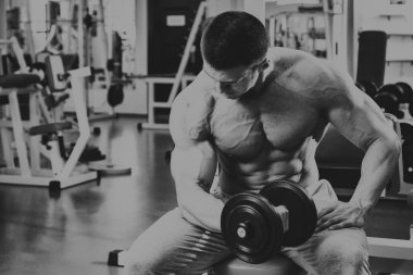 Vücut geliştirmeci yapar egzersiz jimnastik salonu dumbbells ile.