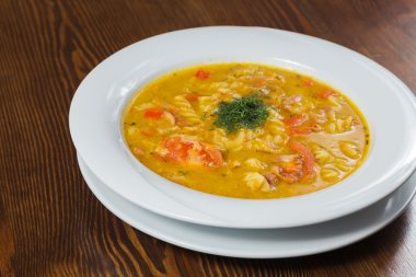 Çorba, sebze ve otlar beyaz plaka.