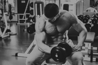 Vücut geliştirmeci yapar egzersiz jimnastik salonu dumbbells ile.