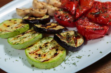 Beyaz tabakta lezzetli çeşitli ızgara sebze.