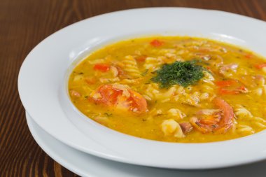 Çorba, sebze ve otlar beyaz plaka.