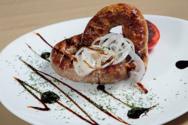 Izgarada pişirme. Izgara sosis kızartma. Izgara menü. Domuz sosisi bir plaka üzerinde.