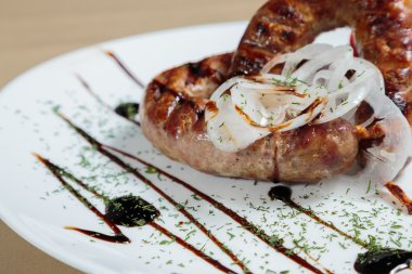 Izgarada pişirme. Izgara sosis kızartma. Izgara menü. Domuz sosisi bir plaka üzerinde.