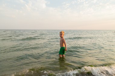 Sahilde erkek şort. Deniz kum ile oynayan çocuk. Sevinç ve eğlenceli çocuklar için. Güzel sıcak bir gün. Çocuk dergi ve Web siteleri için fotoğraf.