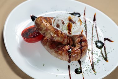 Izgarada pişirme. Izgara sosis kızartma. Izgara menü. Domuz sosisi bir plaka üzerinde.
