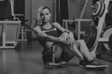 Seksi sarışın kaslı vücudu spor salonunda eğitiyor. Spor sarışın. Güçlü kız.